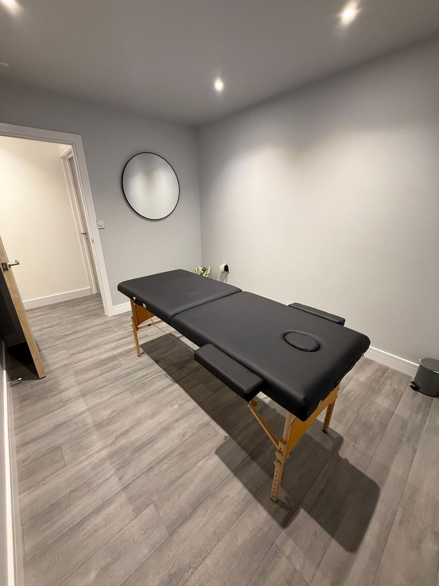 Folded towels and massage oil in the treatment room at Relentless Health & Fitness