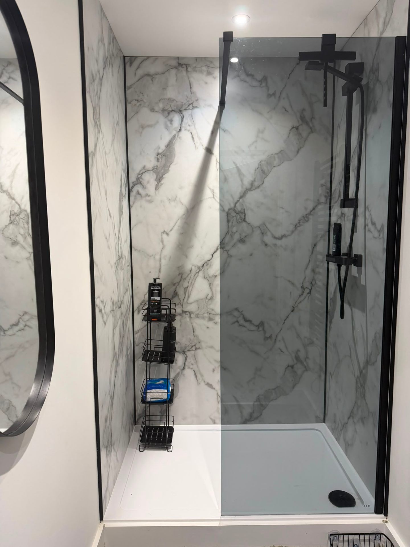 Walk in shower with marble effect tiles and black fittings, available to gym and recovery room users at Relentless Health & Fitness in Attleborough